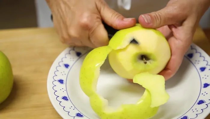 Pelar la manzana reservada y cortarla en láminas finas para decorar la tarta.