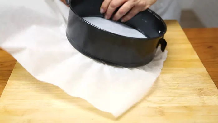 Forrar un molde de horno de 20 a 22 cm de diámetro con papel sulfurizado y untar con mantequilla.