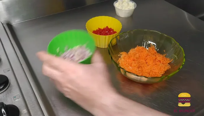 Preparar el relleno: mezclar la zanahoria rallada, cebolla morada picada, pimentón rojo picado, queso crema, sal, ajo en polvo, pimienta y orégano. Integrar bien. [67.92]