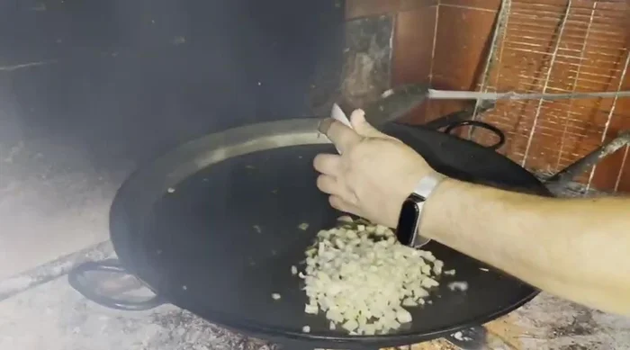 En la paella, dorar la cebolla picada. (353.6)