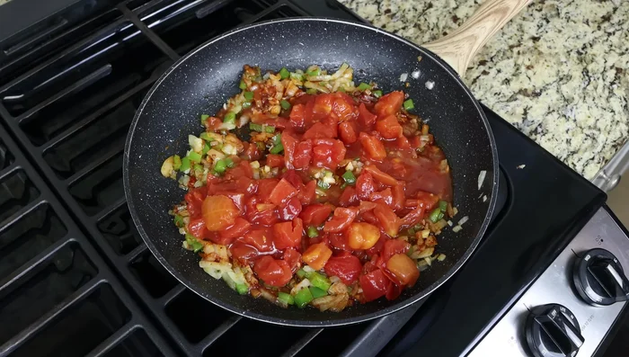 Incorporar los tomates cortados en cubitos, las judías verdes, sal y pimienta. Mezclar bien y cocinar a fuego lento unos minutos.