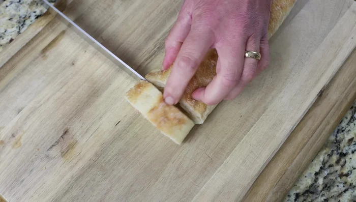 Cortar el pan en rebanadas de 2.5 cm de grosor, pelar los dientes de ajo y reservar 12 almendras crudas blanqueadas.
