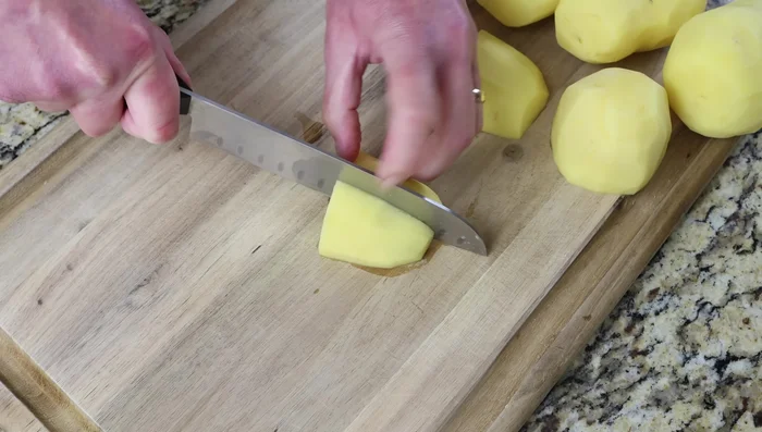 Cortar las patatas peladas, lavadas y secas en trozos del tamaño de un bocado (aprox. 3/4 de pulgada de grosor).