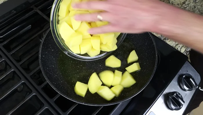 Agregar las patatas a la sartén con el aceite caliente y freír durante 10 minutos, removiendo de 2 a 3 minutos para que se frían uniformemente.
