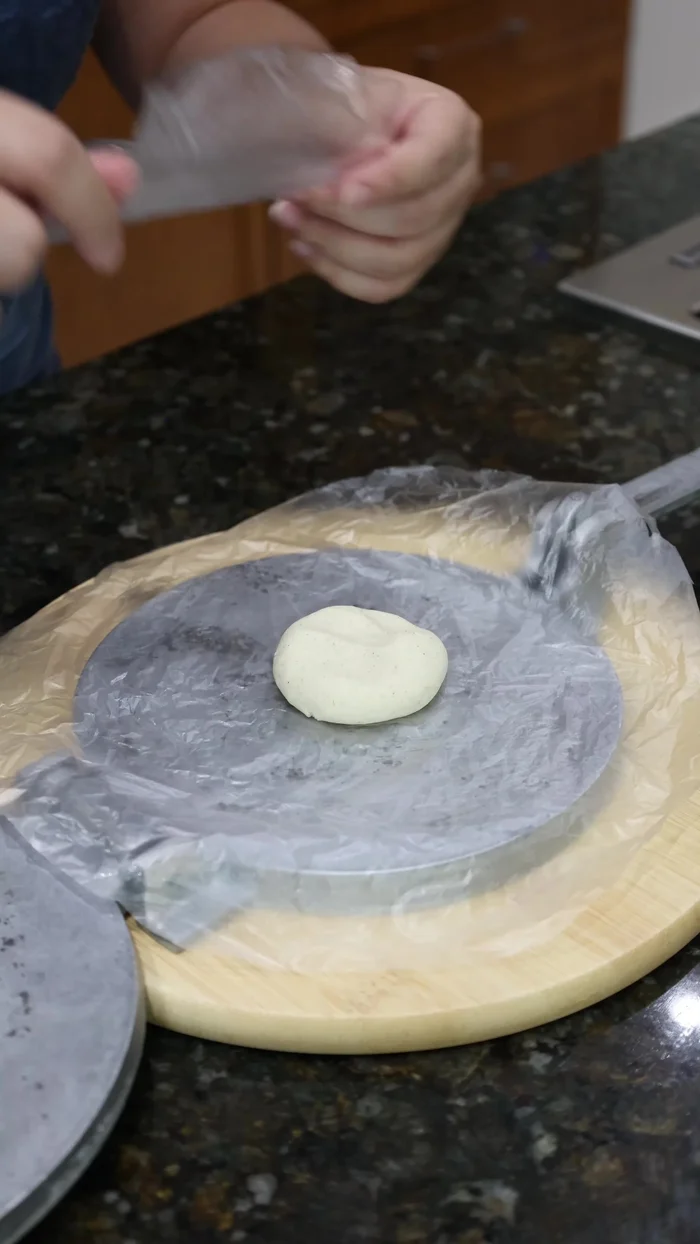 Formar bolitas de masa, aplanarlas con una máquina para tortillas hasta obtener tortillas delgadas. Cocinarlas en una sartén o comal hasta que se inflen. (81.439)
