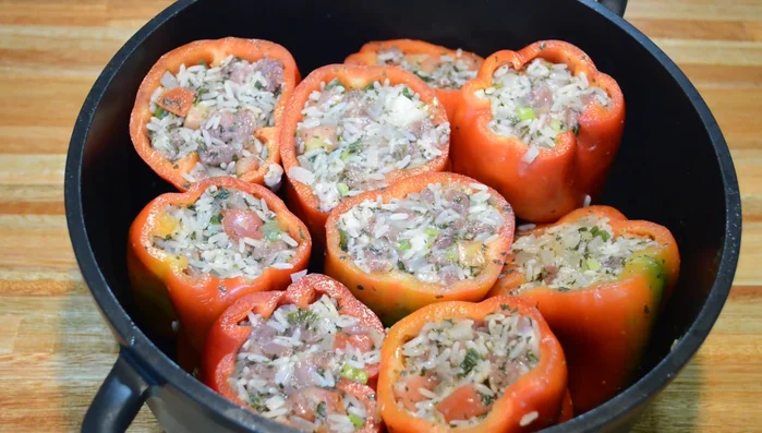Colocar los pimientos rellenos en una olla en forma vertical, agregar una rodaja de tomate encima de cada uno. (199.319)