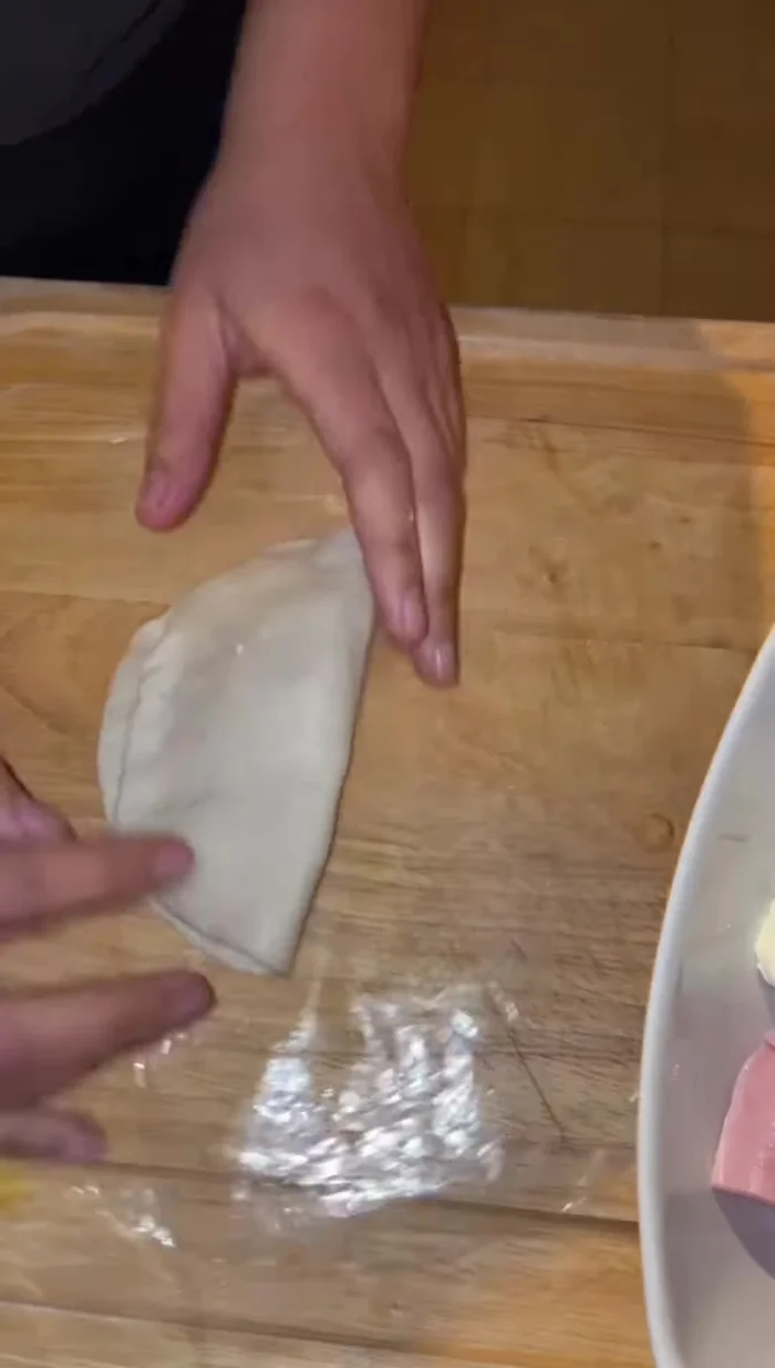 Agregar jamón y queso al centro de cada círculo de masa.