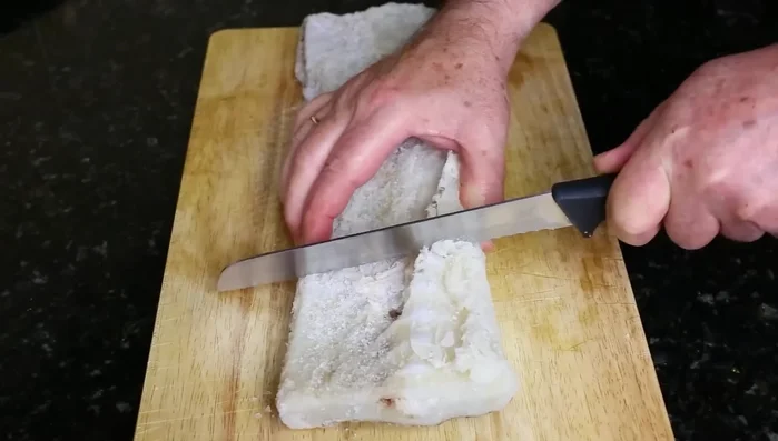 Desalar el bacalao (1kg) en agua fría durante 48h, cambiando el agua cada 8h.