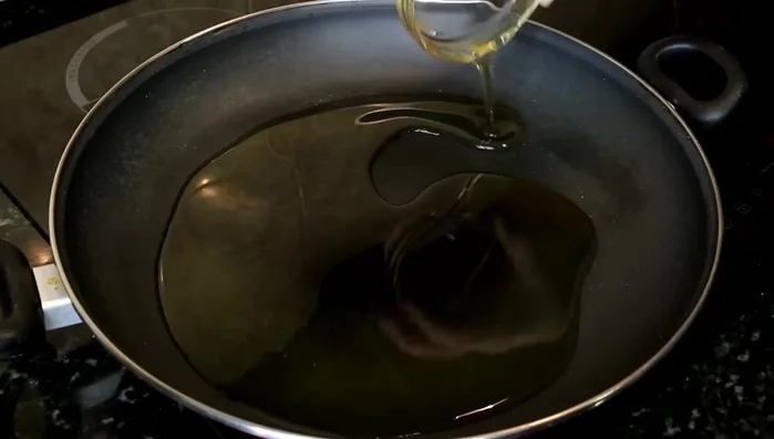 Bacalao al ajo: En una sartén con aceite, freír ajos laminados. Reservar. En la misma sartén, añadir los trozos de bacalao con ajos enteros. [Música]