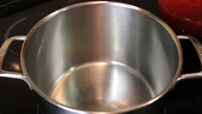 Bacalao con tomate: En una olla, sofreír tomate triturado con aceite y sal. Tapar y remover ocasionalmente.