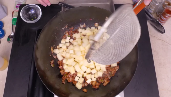 Agregar las papas rojas cortadas en dados y sofreír.
