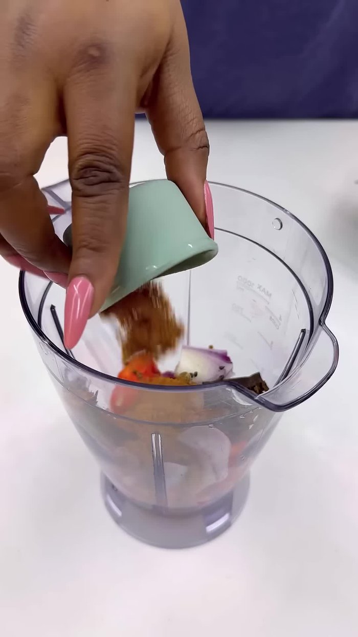 Prepara la base para la pasta de sopa de pimienta: Mezcla pimientos, cebollas, especias, hojas aromáticas, ajo, condimento y agua hasta obtener una pasta suave.