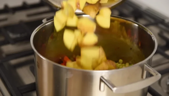 Agregar guisantes partidos, papas y garbanzos. Agregar caldo o agua.