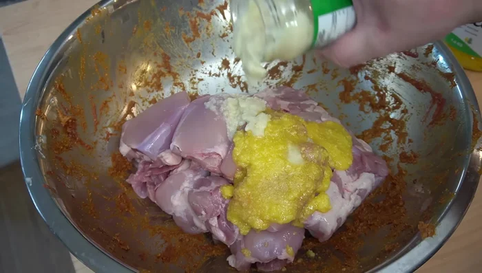 Marinar el pollo Shawarma con ghee, pasta de ajo y jengibre, especias Shawarma, pimentón y chile en polvo. Marinar por al menos 5 horas.