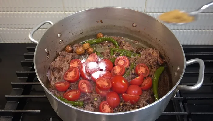 Agregar 12 tomates, sal, cilantro, comino, pimentón y Grand Masala. Saltear durante 10 minutos.