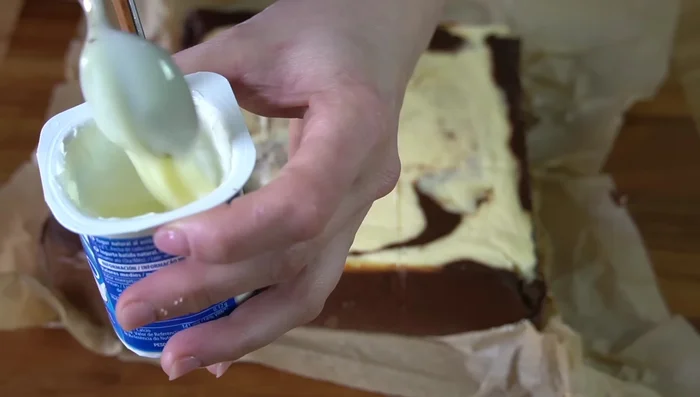 Si se desea, mezclar medio yogur con una cucharadita de leche condensada y esparcir sobre la tarta.