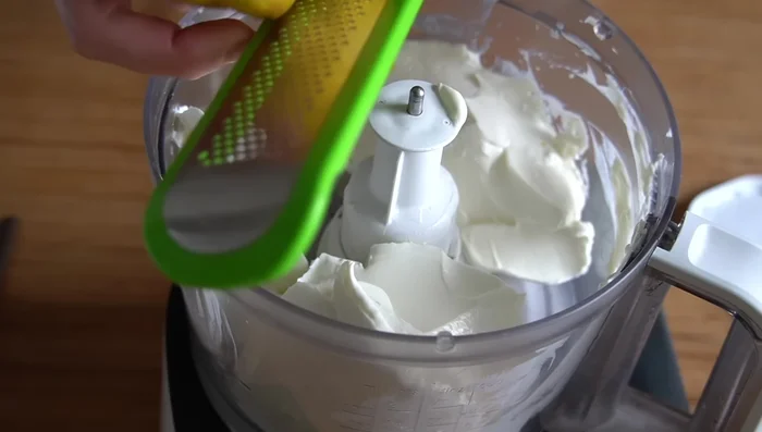 En un procesador, mezclar 600g de queso crema, ralladura de un limón, tres o cuatro cucharadas de sémola de trigo, azúcar al gusto y dos huevos.