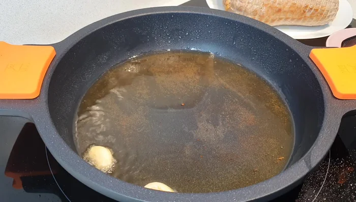 Agregar los ajos enteros a la cazuela, luego las cebollas cortadas en juliana y rehogar con sal y pimienta. Añadir las hojas de laurel.