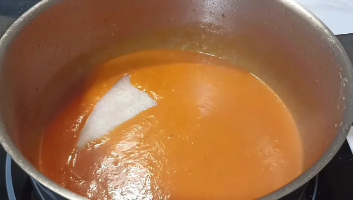 Añadir los filetes de merluza a la salsa, asegurándose de que estén cubiertos completamente.