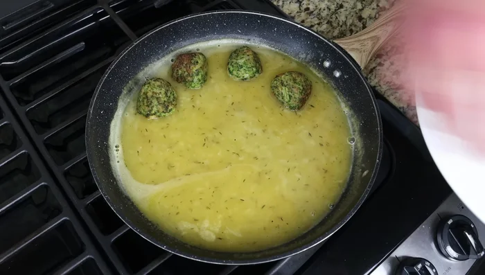 Agregar las albóndigas de brócoli a la salsa y cocinar a fuego lento durante 2-3 minutos.