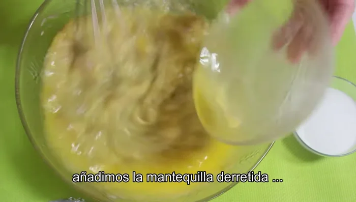 Incorporar la mantequilla derretida, la esencia de vainilla, el azúcar moreno y el azúcar blanco. Mezclar bien hasta que el azúcar se disuelva.