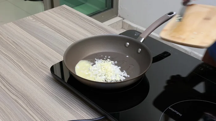 Añadir la cebolla y el ajo finamente picados y freír.