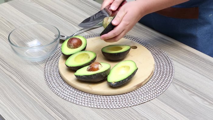 Cortar los aguacates por la mitad, quitarles la semilla y sacarles la pulpa con una cuchara.