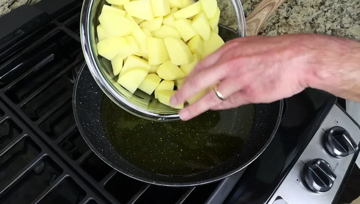 Agregar las patatas a la sartén caliente y mezclar para cubrirlas con el aceite. Freír, mezclando cada 3-4 minutos, hasta que estén doradas (25-30 minutos). (136.48)