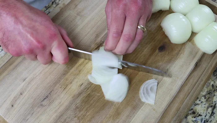 Mientras las patatas se fríen, cortar en rodajas finas 3 cebollas medianas y 6 dientes de ajo. Reservar. (157.16)