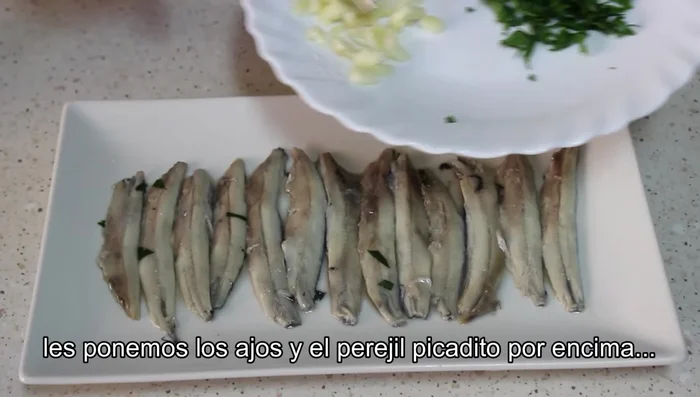 Añadir el ajo y el perejil picados a los boquerones.