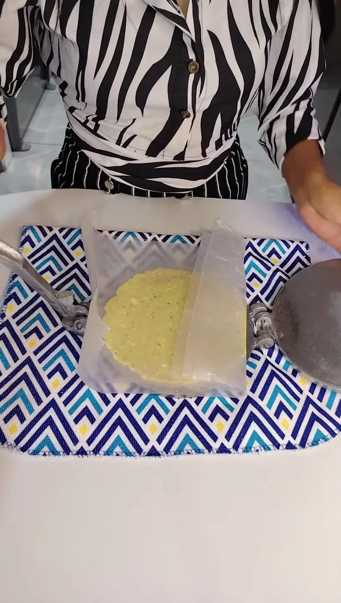 Colocar cada bolita entre dos láminas de papel encerado o fundas plásticas y presionar para formar las empanadas.