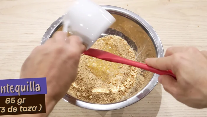 Mezcla las galletas machacadas con la mantequilla derretida. (42.239)