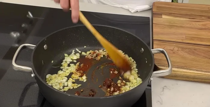 Agregar una cucharada de pimentón, la salsa de tomate, un vaso de vino blanco y un poco del caldo de los guisantes.