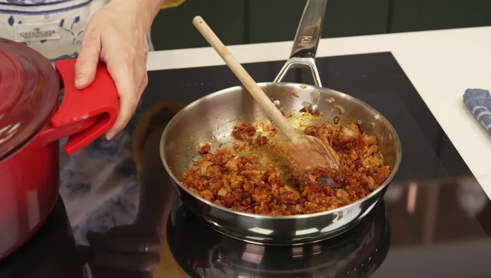 Agregar el sofrito a la cazuela con los garbanzos cocidos (retirar cebolla, ajos y laurel previamente).