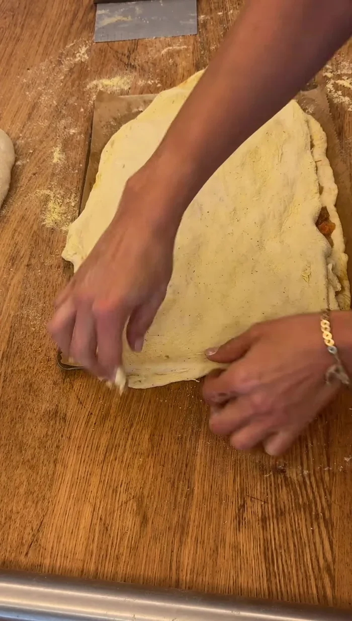 Sellar los bordes de la empanada, realizando un repulgue.