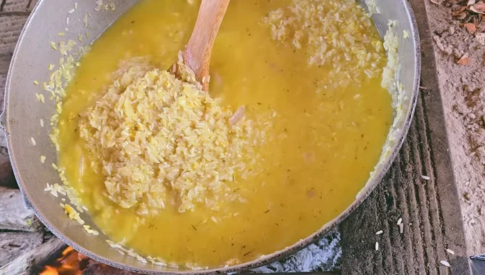Agregar agua (la cantidad usual para el arroz) y un poco de caldo de costilla para darle sabor. Agregar sal.