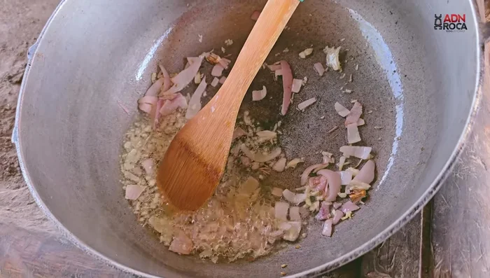 Agregar el arroz escurrido al caldero y sofreír un poco para sellarlo.