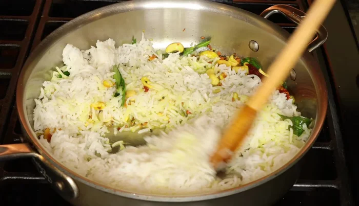 Agrega el arroz cocido a la sartén, apaga el fuego y mezcla suavemente.