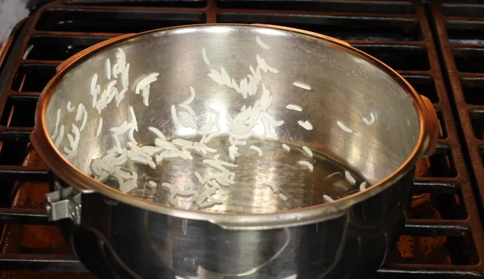 Escurre el arroz un minuto antes de que esté completamente cocido. Vuelve a ponerlo en la olla, cúbrelo durante unos minutos.