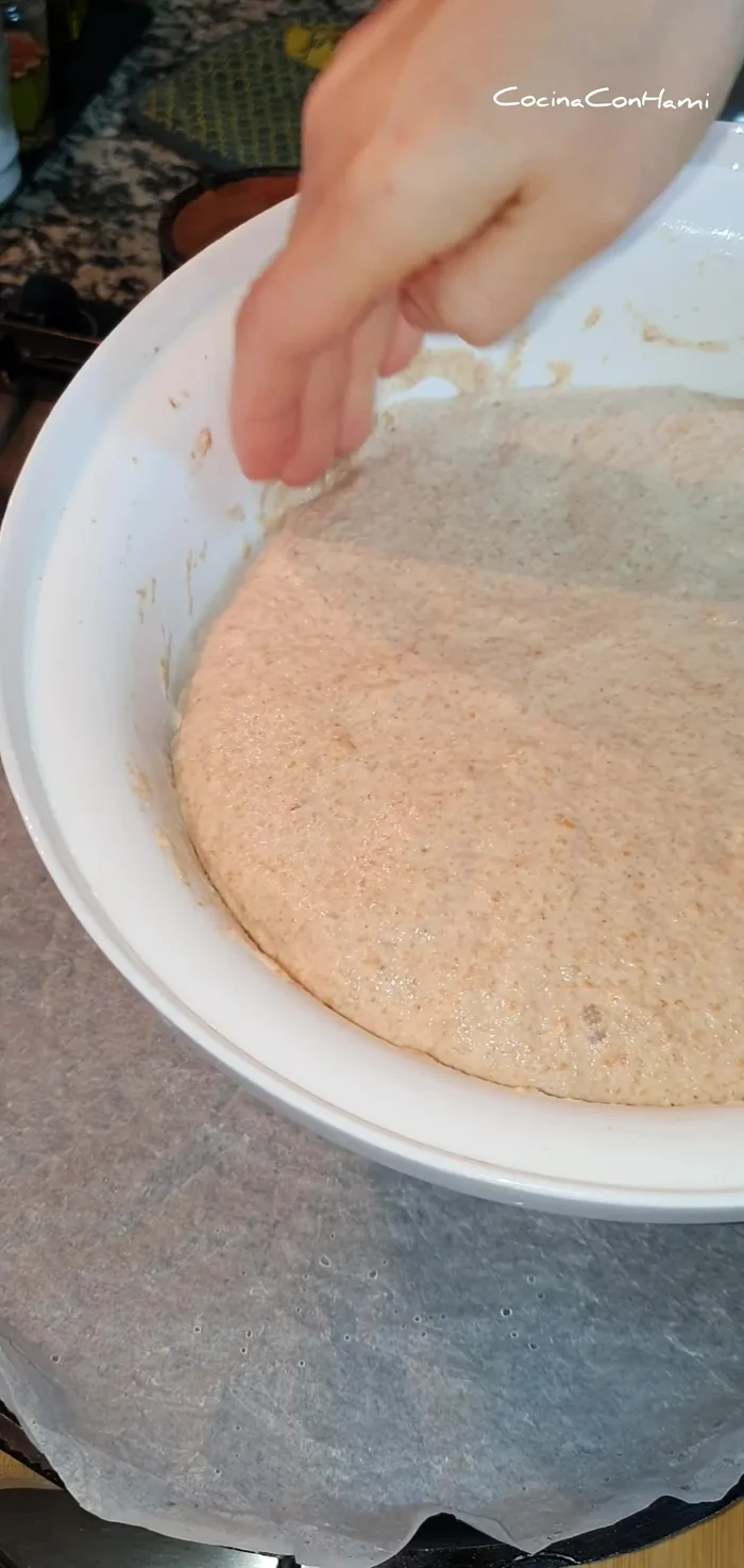 Volcar la masa sobre una bandeja de horno o molde, extendiéndola con las manos mojadas hasta un grosor de aproximadamente un dedo. Decorar con sésamo si se desea.