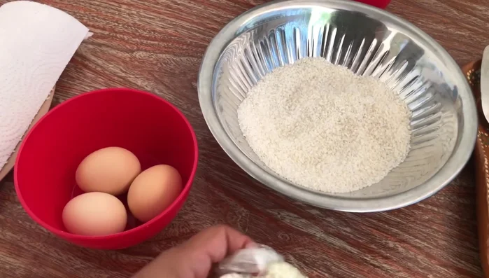 En un bowl, mezclar el arroz molido con 2 huevos y queso. Agregar más huevos o queso según sea necesario para obtener una consistencia manejable.