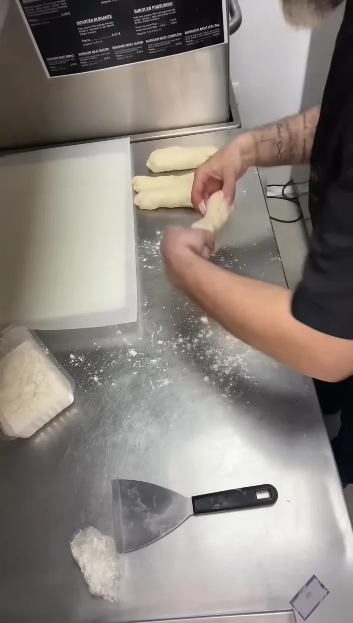 Colocar las baguettes sobre una tabla con papel vegetal, dejando espacio entre ellas. Hacer un corte en la superficie de cada baguette.