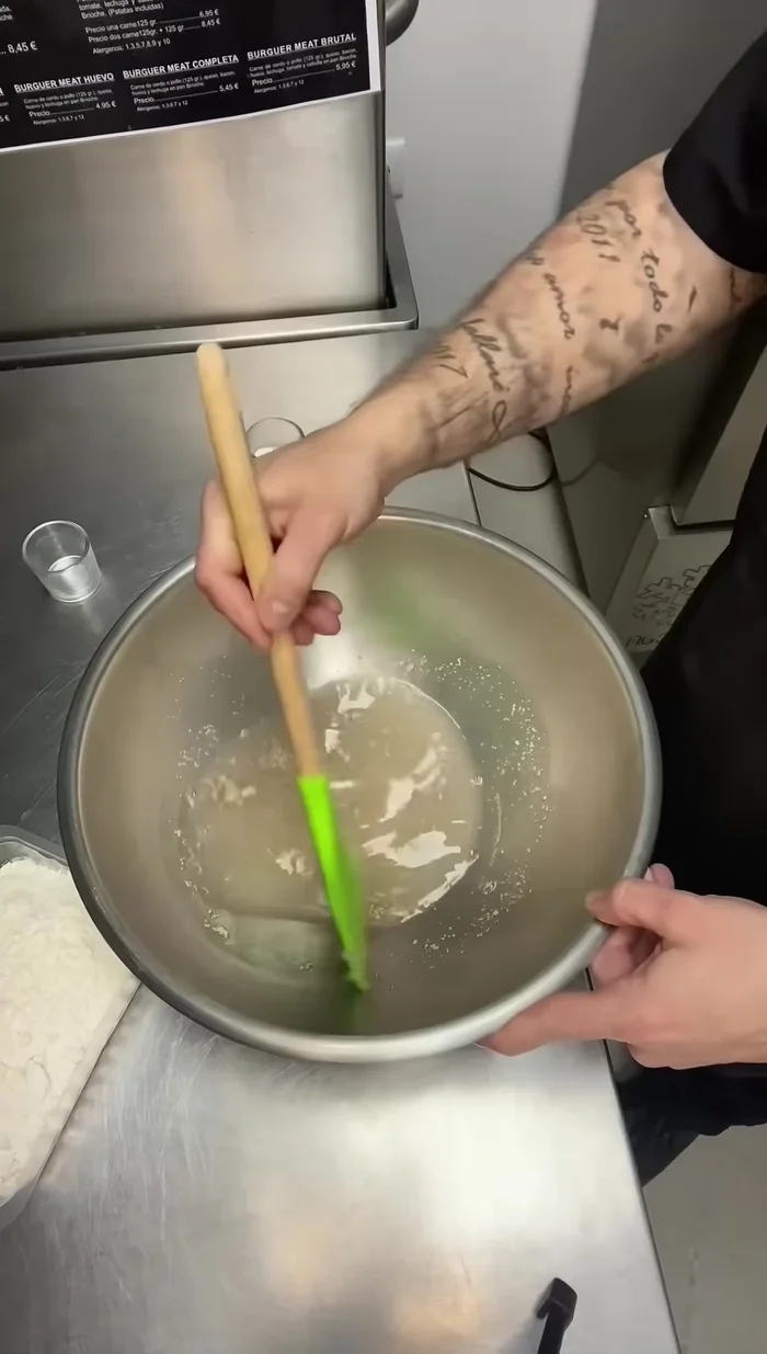 En un bol, mezclar el agua (no fría), la levadura y menear hasta que se disuelva.