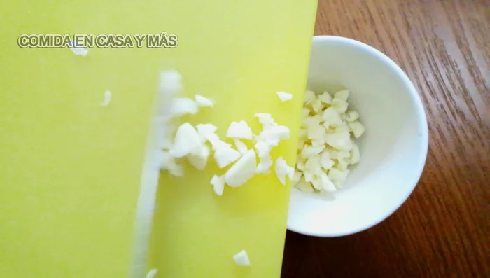 Picar los ajos, la cebolla y los pimientos (rojo, verde y amarillo).