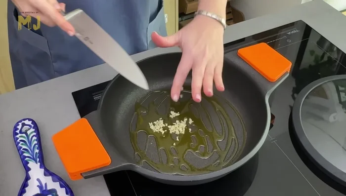 En una cacerola, echamos un chorrito de aceite de oliva virgen extra, incorporamos el ajo y lo doramos ligeramente.