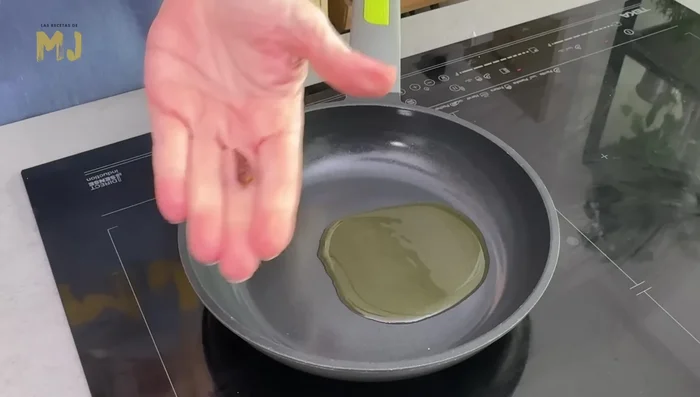 Preparar el aceite de pimentón: Calentar aceite de oliva virgen extra en una sartén, añadir una cucharadita de pimentón picante y mezclar durante 20 segundos.