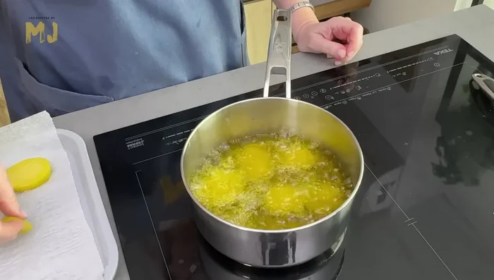 Freír las patatas por tandas en abundante aceite de oliva virgen extra hasta dorarlas al gusto. Escurrir sobre papel de cocina.
