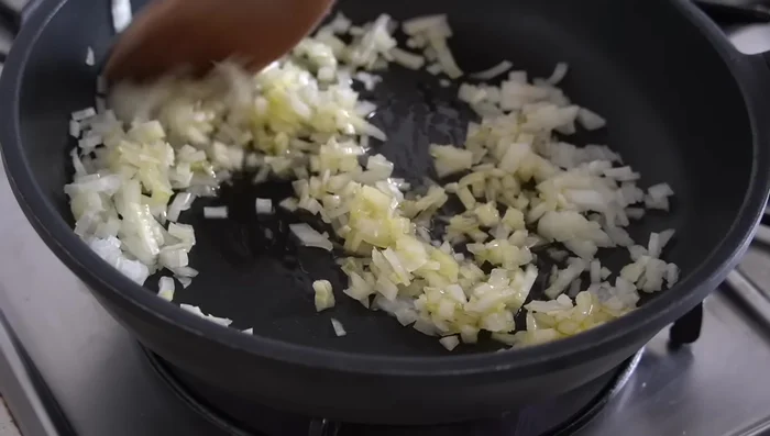Sofríe la cebolla y la zanahoria picadas finamente en aceite de oliva hasta que estén doradas. (154.16)
