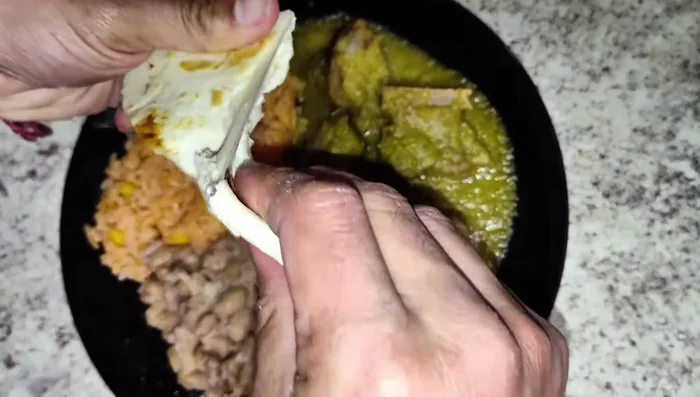 Servir las costillas en salsa verde con arroz rojo y frijoles.