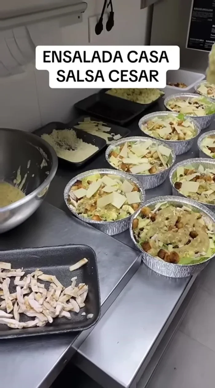 Bañar la ensalada con la salsa César y espolvorear con parmesano rallado adicional para decorar.